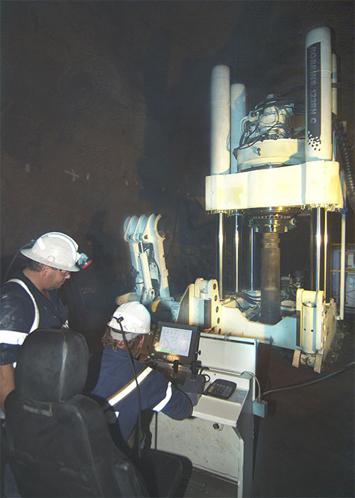 Miners operating raise drill underground