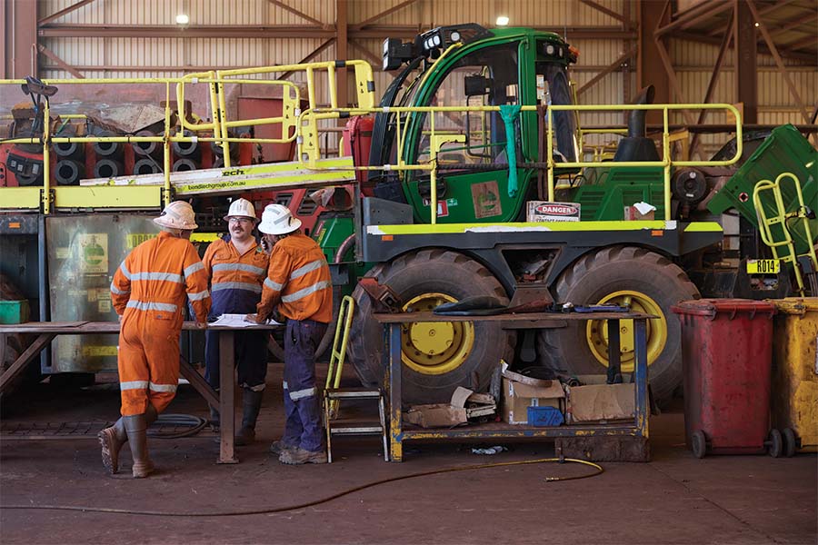 Miners discussing beside raise drill